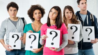 Millennials hold up question mark signs questioning their future.