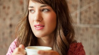 A woman drinks a cup of tea to cope with stress