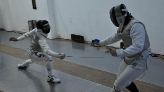 Two people participate in fencing