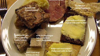 A plate of Iceland food is pictured featuring whale blubber, sheep testicles and head cheese