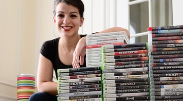 Sarkeesian with a pile of video games