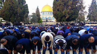 Muslim men praying outside a mosque