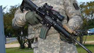 Pictured is a military member with a firearm